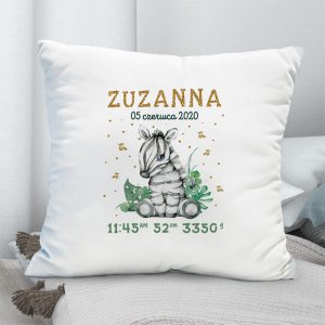 Biała poduszka dekoracyjna do pokoju dziecka. Na poszewce znajduje się grafika małej zebry oraz metryczka z danymi dziecka zaraz po urodzeniu.