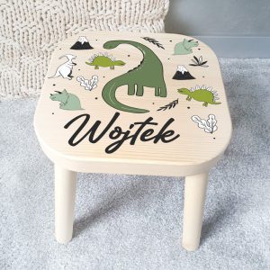 Drewniany taboret dziecięcy z rysunkiem dinozaurów i imieniem na wieczku.