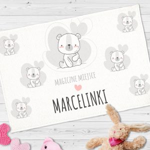 51 Ozdobny dywanik do pokoju dziecięcego. Na jasnym tle wizerunek białego misia na szarej chmurce i personalizacja.