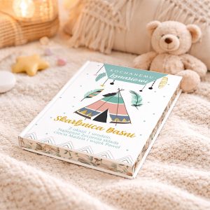 Książka z kolorową okładką leży na jasnym, miękkim kocu. Okładka zdobiona jest ilustracją namiotu i piór, z napisem 'Skarbnica Baśni' oraz dedykacją na pierwsze urodziny. Obok znajduje się pluszowy miś.