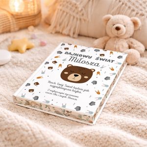 Książka zatytułowana 'Bajkowy świat Miłosza', z ilustracją niedźwiedzia na okładce, leży na przytulnej kocyku obok pluszowego misia i dekoracji w kształcie gwiazdy oraz kolorowych słodyczy.