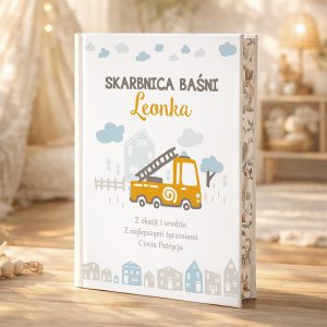 Książka dla dziecka o tytule "Skarbnica Baśni Leonka", z ilustracją pomarańczowego wozu strażackiego na okładce, ozdobiona pastelowymi chmurkami i domkami, z dedykacją z okazji pierwszych urodzin od Cioci Patrycji.