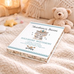 Skarbnica Baśni, kolorowe pudełko z misio-kotem, leży na jasnym kocyku obok pluszowego misia.