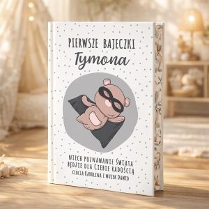 Ilustracja okładki książki "Pierwsze bajeczki Tymona", przedstawiająca pluszowego misia w masce superbohatera na tle jasnym z kropkami.