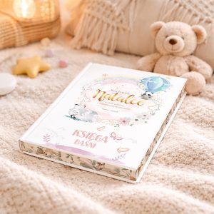 personalizowane-bajki-dla-dziecka-dziewczynka Książka z tytułem "Kochane Natalce" leży na miękkim, jasnym kocu w otoczeniu zabawek i dekoracji dziecięcych.