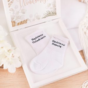 Białe skarpetki z napisem "Będziesz Dziadkiem" i "Będziesz Babcią" w ozdobnym pudełku.