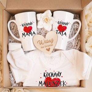 Zestaw prezentowy zawierający dwa kubki z napisami „Kochana Mama” i „Kochany Tata”, a także body dla dziecka z napisem „Kochany Maluszek” i drewnianą tabliczką „Witaj na świecie”.