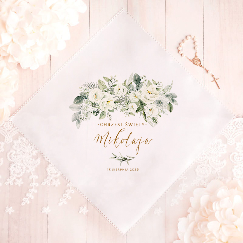 Elegancka chusta z nadrukiem kwiatów, na tle drewnianego stołu, z napisem 'CHRZEST ŚWIĘTY Mikołaja' oraz datą '15 sierpnia 2026', otoczona delikatnymi dodatkami w postaci koralikowej różańca i koronkowych elementów.