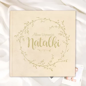 Beżowy album ze złotą grafiką, na której widnieje napis "Album Wspomnień Natalki" otoczony delikatnym ornamentem roślinnym.
