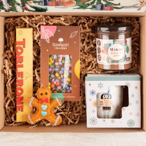 Kolorowy box świąteczny z prezentami pod choinkę zestaw prezentowy ze słodyczami i kubkiem w świątecznym motywie