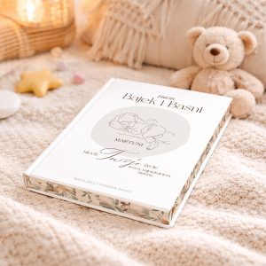 zbior-bajek-i-basni-dla-dziecko-z-personalizacja Biała książka zatytułowana "Zbiór Bajek i Baśni" leży na miękkim kocyku, otoczona pluszowym misiem i dekoracyjnymi gwiazdkami.