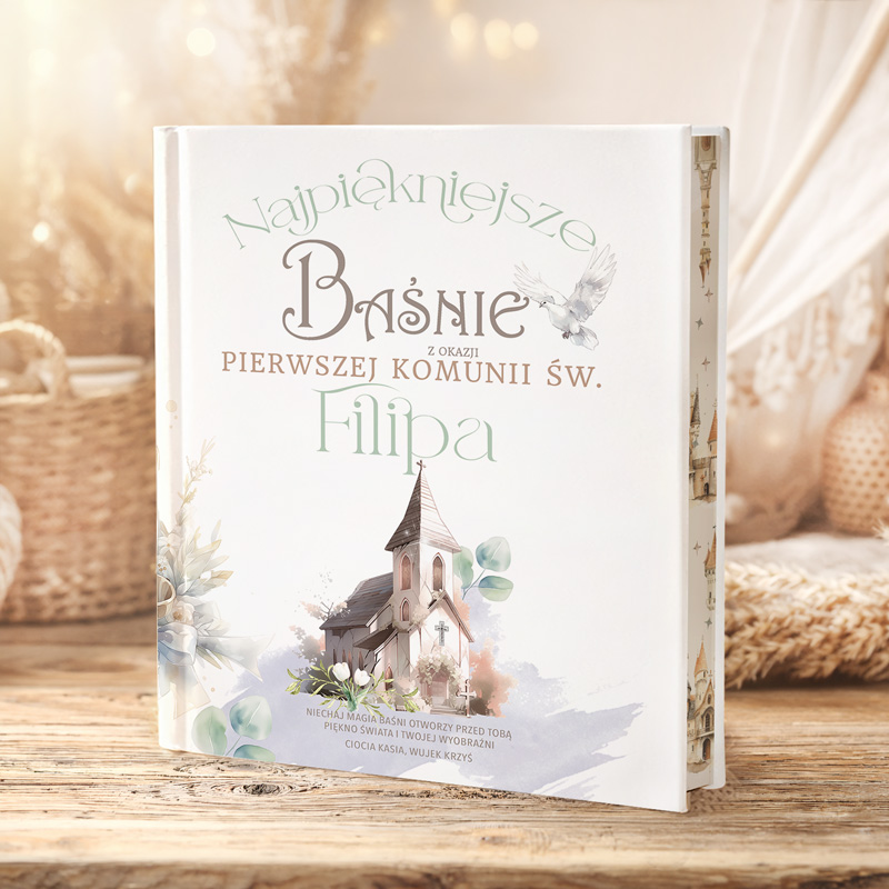 Ozdobna książka zatytułowana "Najpiękniejsze Baśnie" z grafiką kościoła i elementami florystycznymi, z dedykacją dotyczącą pierwszej komunii.