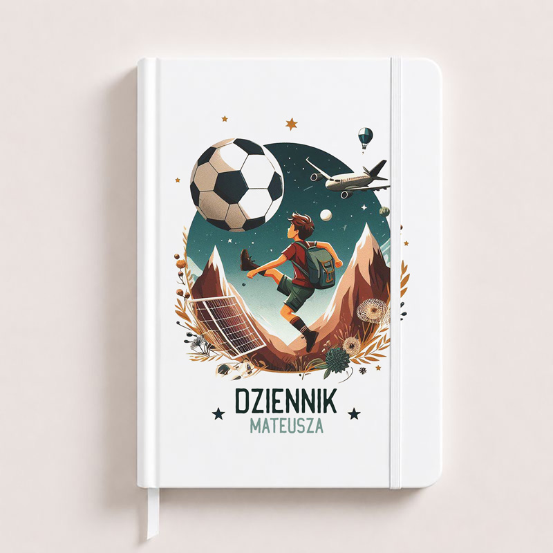Kreatywny dziennik z ilustracją chłopca grającego w piłkę nożną w kosmosie, z dodatkowymi motywami gór i statków powietrznych.