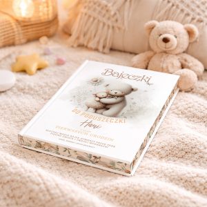 Książka zatytułowana 'Bajeczki do poduszeczki Hani' leży na miękkim, jasnym kocu, obok niej znajduje się pluszowy miś i inne dekoracyjne elementy, jak gwiazdka i kolorowe cukierki.