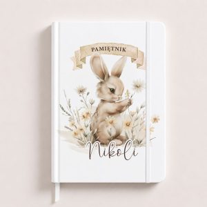 A notebook featuring a cute bunny holding a flower, with the text "PAMIĘTNIK" and the name "Nikoli" underneath.