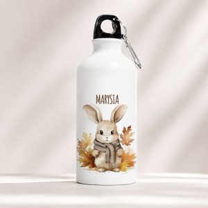 Biała bidon z ilustracją królika w szaliku i kolorowymi liśćmi, z napisem "MARYSIA" na górze.