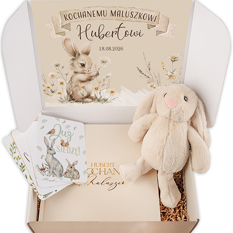 Kartonowe pudełko z prezentem, w którym znajduje się pluszowy króliczek oraz karty z ilustracjami króliczków i ptaków, a na górze widnieje ozdobna karta z napisem 'Kochanemu Maluszkowi Hubertowi 18.08.2026'.