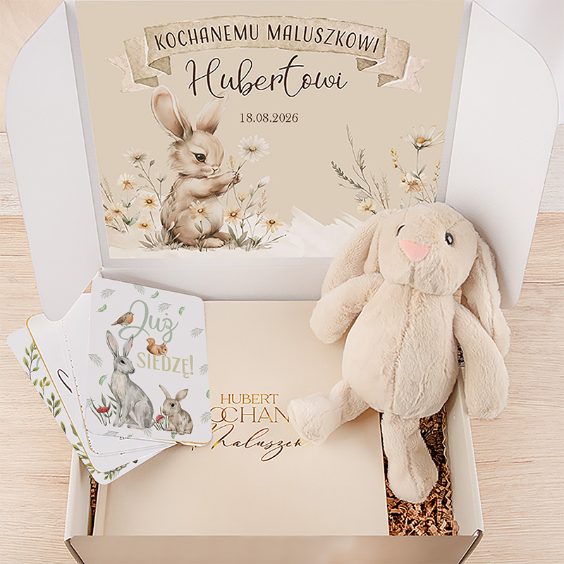 Otwarta, ozdobna paczka z przedstawieniem pluszowego zająca, stylizowanej karty z rysunkiem zająca i napisem, oraz dekoracyjnym tłem z motywem kwiatowym i datą 18.08.2026.