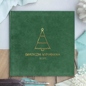 Zielony album na zdjęcia z napisem "Świąteczne Wspomnienia 2025" i ilustracją choinki na okładce, leżący na drewnianym stole z dekoracjami w tle.