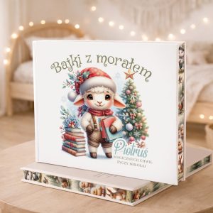 Książka "Bajki z moratem" z ilustracją uroczej owieczki stojącej obok choinki, otoczona dekoracjami świątecznymi.