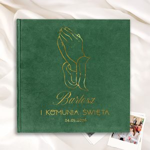 Zielona oprawa książki z ilustracją złożonych rąk na okładce, z napisem 'Bartosz I KOMUNIA ŚWIĘTA 24.05.2026' w złotym kolorze, leżąca na jasnym tle z materiału i zdjęciami w tle.