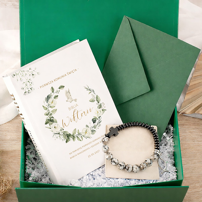 Zielony zestaw prezentowy zawierający Biblię z dekoracyjną okładką, kopertę oraz bransoletkę z kamieniami.