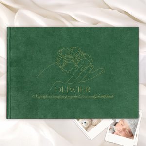 Zielona okładka książki z ilustracją dłoni trzymającej małe buciki oraz napisem 'OLIWIER' i hasłem o szczęściu związanym z małymi stópami, leżąca na białym tle z zdjęciami i pluszowym misiem obok.