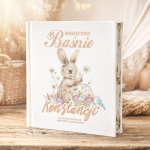 Książka z tytułem "Magiczne Baśnie" z ilustracją królika trzymającego kwiaty, ozdobiona delikatnymi motywami roślinnymi.