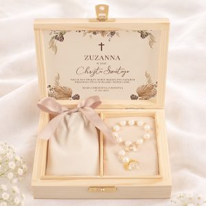 Elegancka skrzynka z drewnianymi akcentami, zawierająca naszyjnik oraz sakralny dokument z imieniem Zuzanna i datą chrztu.