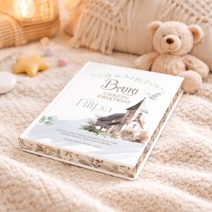 Książka "Najpiękniejsze Bajki z Okazji Chrztu Świętego Filipa" leży na miękkim kocyku w otoczeniu zabawek, w tym pluszowego misia i gwiazdki, w jasnym, przytulnym wnętrzu.