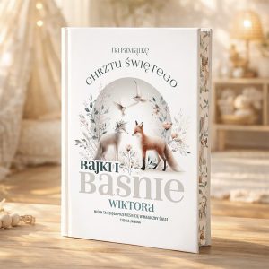 Książka o tytule 'Bajki i Baśnie Wiktora' z elegancką okładką, przedstawiającą dwa lisy w otoczeniu kwiatów i ptaków, z napisem 'na pamiątkę Chrztu Świętego'. Na stole w tle widoczne są przytulne elementy wystroju wnętrza.