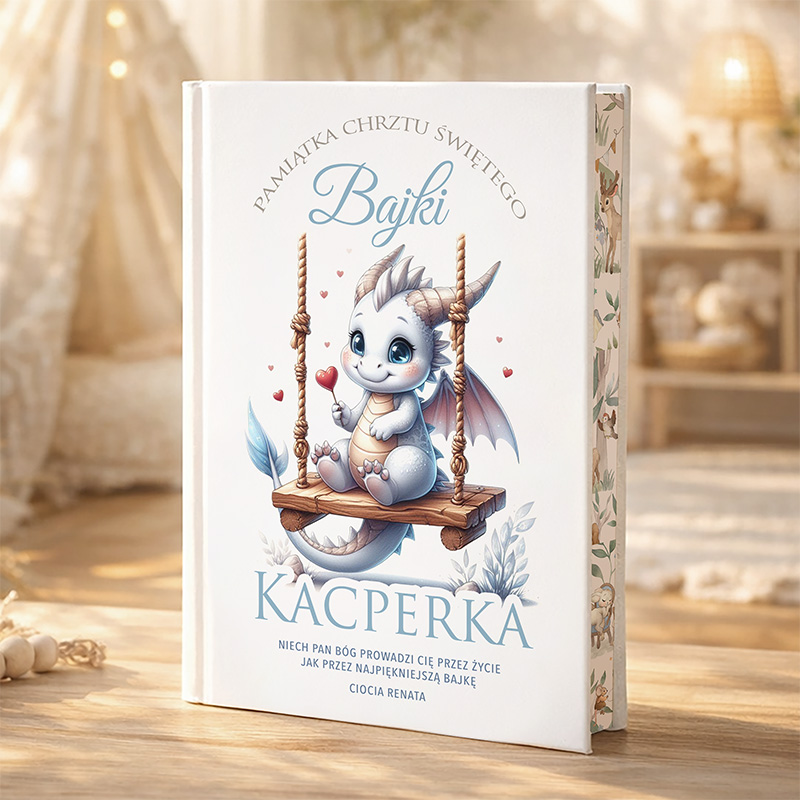 Książka dziecięca z ilustrowanym smoczkiem na huśtawce, na okładce napisane 'Bajki Kacperka' oraz 'Pamiątka Chrztu Świętego'. Tło to jasne, przytulne pomieszczenie z dekoracjami w stylu skandynawskim.