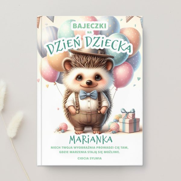 Okładka książki z tytułem "Bajeczki na Dzień Dziecka", przedstawiająca sympatycznego jeża w eleganckim stroju z muszką, stojącego obok balonów i prezentów w pastelowych kolorach.