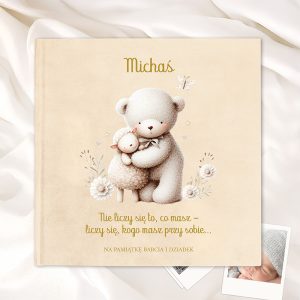 Okładka książki z tytułem 'Michaś', przedstawiająca pluszowego misia przytulającego owcę na tle delikatnych kwiatów. Na dole znajduje się napis: 'Nie licz się to, co masz - licz się, kogo masz przy sobie...' oraz dedykacja 'NA PAMIĄTKĘ BABCIA I DZIATEK'.