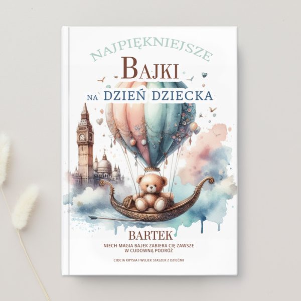 Okładka książki "Najpiękniejsze bajki na Dzień Dziecka" z ilustracją balonu unoszącego się w powietrzu, w którym siedzi pluszowy miś. W tle widać wieżę Big Ben i inne elementy architektury, a tło jest w delikatnych pastelowych kolorach.