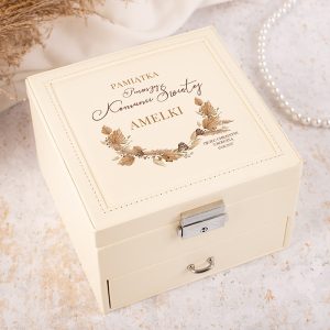 Biała, elegancka szkatułka z napisem "Pamiątka Pierwszej Komunii Świętej Amelki" oraz ozdobnym wzorem roślinnym.