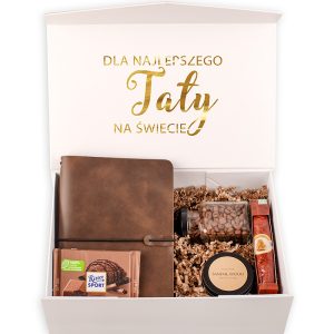 Pudełko z prezentem dla taty, zawierające brązowy notatnik, kawa w słoiku, świeca zapachowa o zapachu sandałowca, czekoladę Ritter Sport oraz słoik z konfiturą, wszystko ustawione na wypełnieniu z papieru.