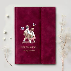 Okładka notesu w burgundowym kolorze z ilustracją dwóch dzieci idących razem, niosących plecaki, otoczonych ptakami; tekst na okładce: "PANI MARZENA Uczy sercem".