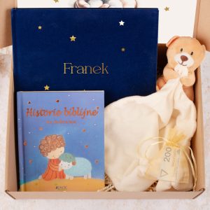 Zestaw prezentowy w pudełku, zawierający książkę 'Historie biblijne na dobranoc', pluszowego misia w kocyk oraz personalizowaną niebieską okładkę z imieniem 'Franek'. Obok znajduje się mały woreczek z kartką.