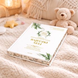 bajki-personalizowane-prezent-komunijny Książka z białą okładką z delikatnymi roślinnymi wzorami, tytuł 'Bajeczki Neli' widoczny na górze, leży na jasnym, plisowanym pledzie obok pluszowego misia i dekoracyjnych elementów w pastelowych kolorach.