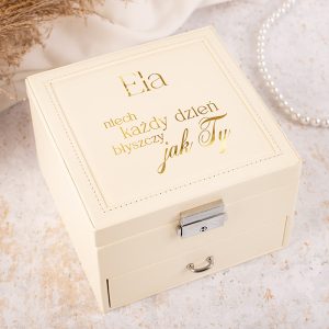 Elegancka, beżowa skrzynka z napisem "Ela niech każdy dzień błyszczy jak Ty" na pokrywie, z ozdobnym zamkiem i szufladą.