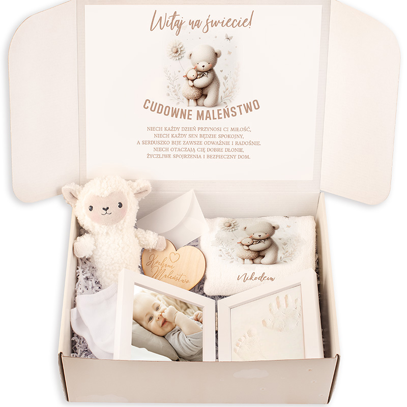 Zestaw powitalny dla noworodka w eleganckim pudełku, zawierający przytulankę w kształcie owieczki, ręczniczek z wizerunkiem misia, drewnianą zawieszkę, zdjęcie niemowlęcia oraz ramki na odcisk dłoni i stóp, z pozdrowieniami w języku polskim na wieczku pudełka.