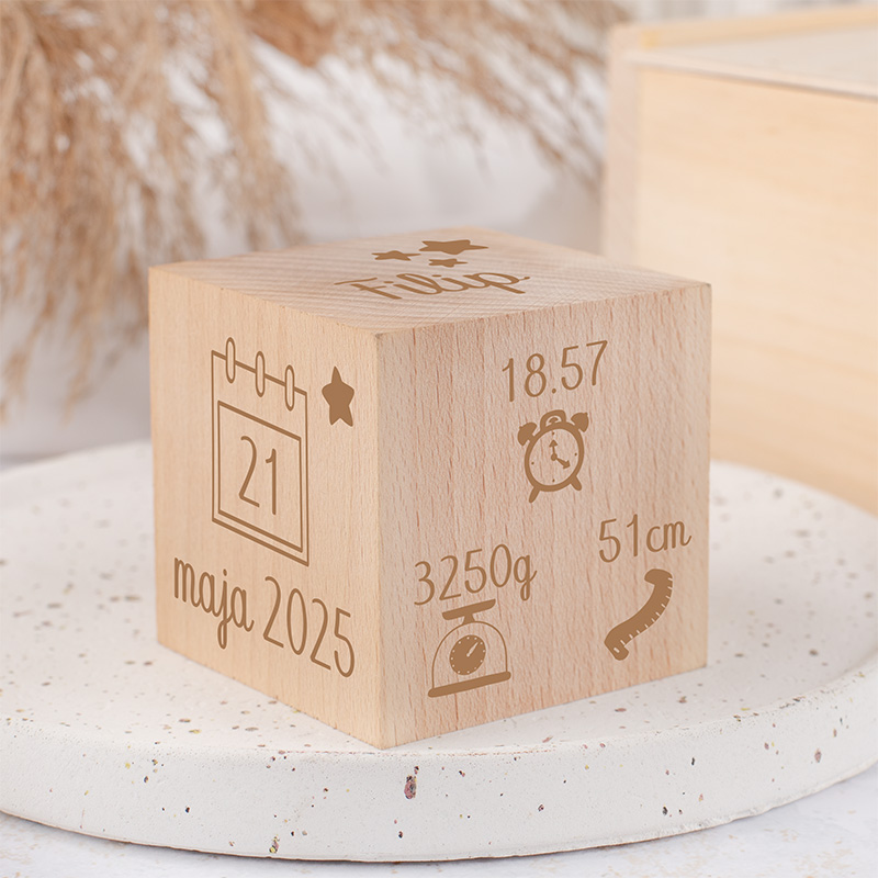 Drewniana kostka z grawerowanymi danymi: imię 'Filip', data '21 maja 2025', waga '3250g', długość '51cm', oraz czas '18.57'.