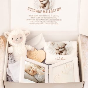 Zamknięte pudełko z zestawem dla niemowlęcia zawierające przytulankę w kształcie owieczki, kocyk z motywem misia, drewniane serce z napisem, zdjęcia dziecka oraz odciski rączek, z tłem inspirowanym nawiązującym do dzieciństwa.