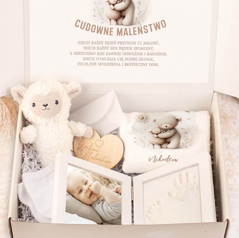 Zamknięte pudełko z zestawem dla niemowlęcia zawierające przytulankę w kształcie owieczki, kocyk z motywem misia, drewniane serce z napisem, zdjęcia dziecka oraz odciski rączek, z tłem inspirowanym nawiązującym do dzieciństwa.