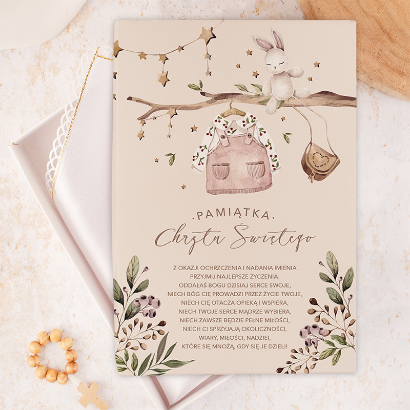 Elegancka karta z okazji chrztu, ozdobiona ilustracjami skarpetek, króliczka i gałązek z liśćmi oraz gwiazdkami, zawierająca życzenia i modlitwy dla dziecka, w pastelowych kolorach na jasnym tle.