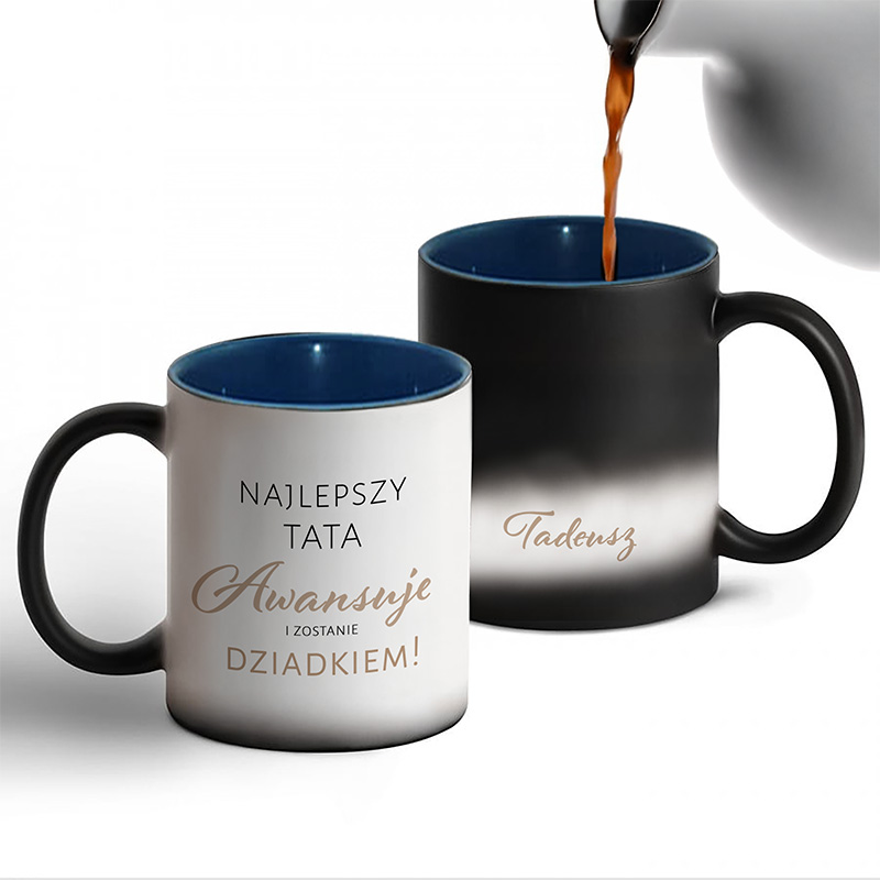 Dwa kubki w kolorze białym i czarnym z napisami. Biały kubek ma napis 'NAJLEPSZY TATA Awansuję i zostanie DZIADKIEM!' w złotym kolorze, natomiast czarny kubek ma napis 'Tadeusz'.