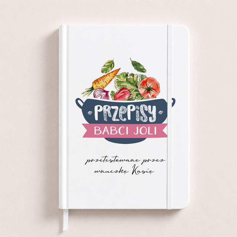 Notes z białą okładką z kolorowym nadrukiem nawiązującym do gotowania, tytuł "Przepisy Babci Joli" z dekoracyjnymi warzywami i owocami.
