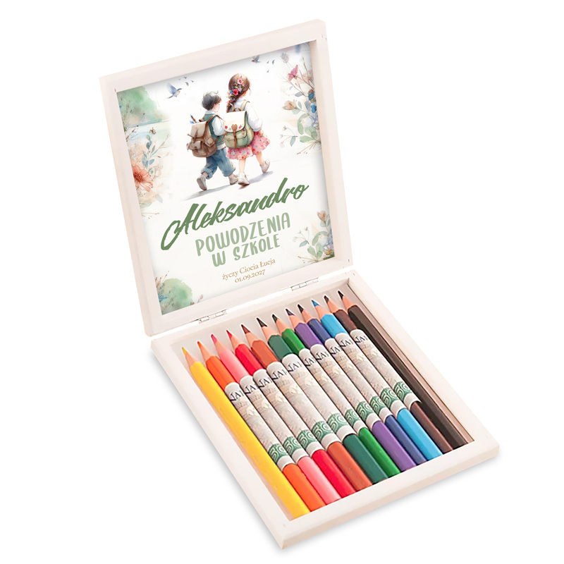 Otwarta pudełko z kredkami, w środku z różnymi kolorami kredkowych ołówków, z górną częścią z wizerunkiem dzieci idących do szkoły oraz napisem 'Aleksandro, powodzenia w szkole'.