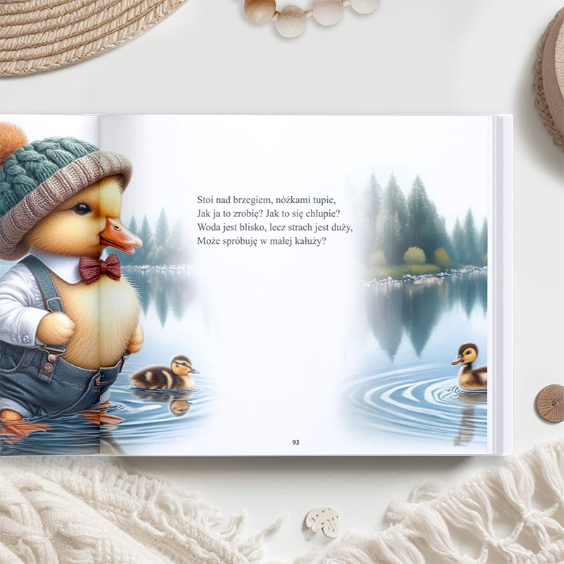 Ilustracja z książki dla dzieci przedstawiająca małego kaczątka w zielonym kapeluszu i muszce, stojącego nad brzegiem wody, nad którym unosi się delikatna mgła. Obok niego pływają dwa inne kaczątka, a w tle widać las i spokojną taflę wody.